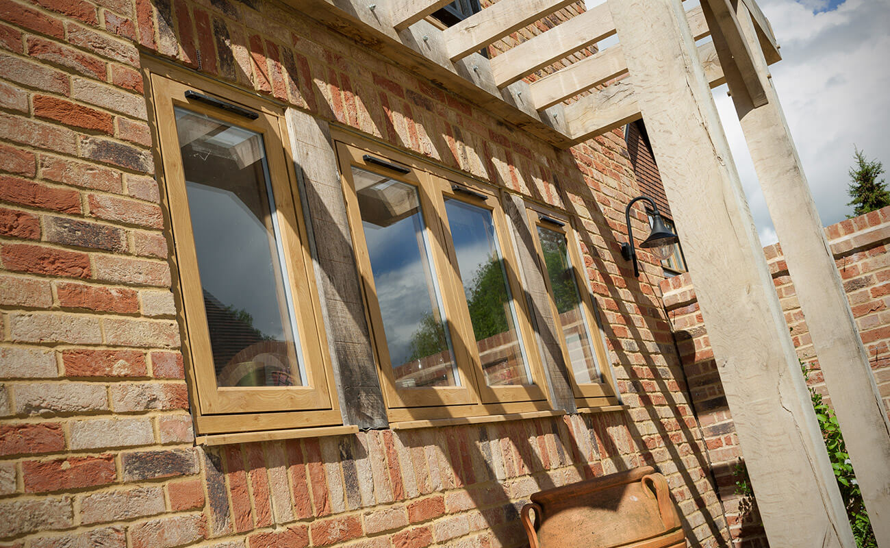 Oak effect residence collection window on brick wall