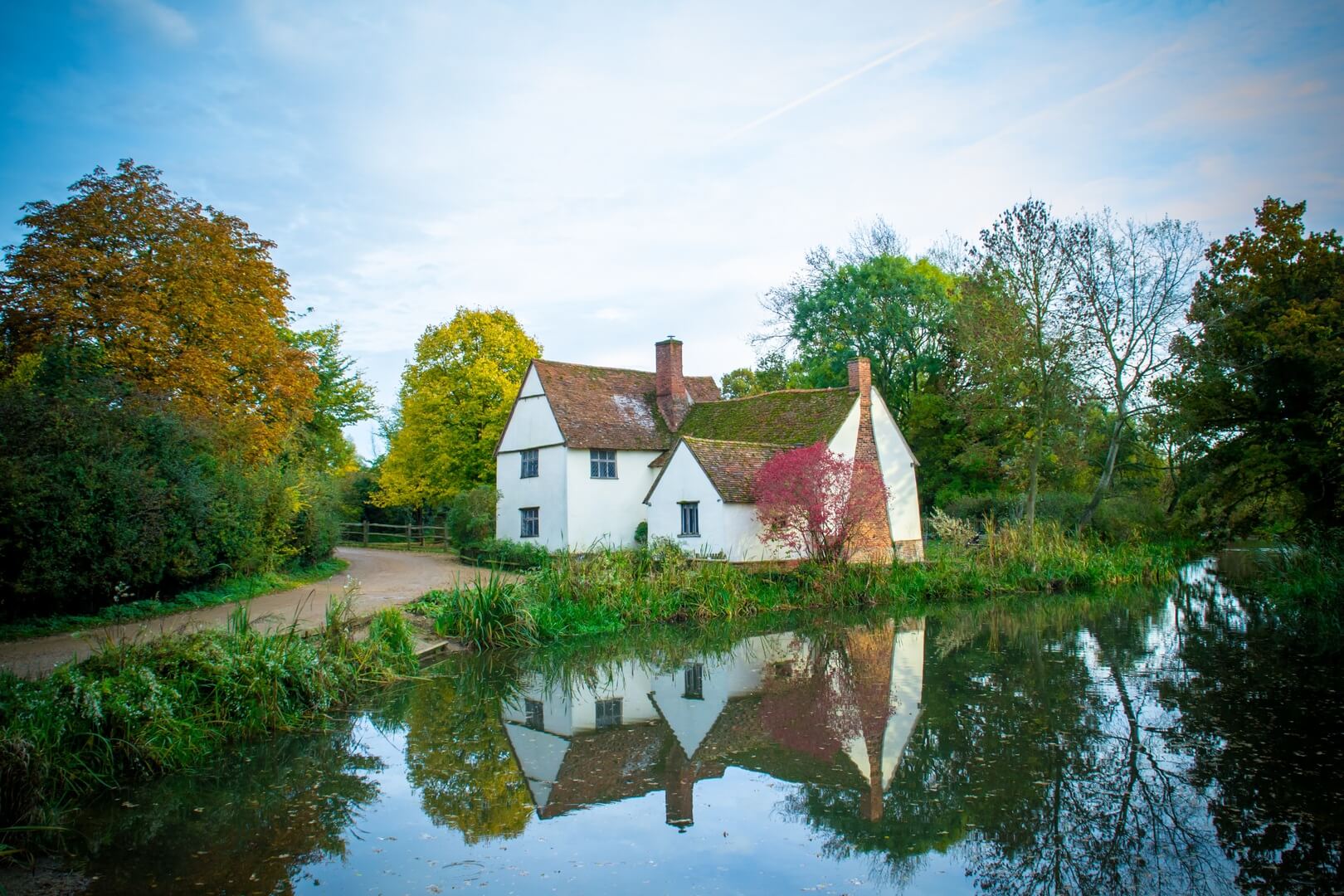 countryside house by a pond surrounding by nature