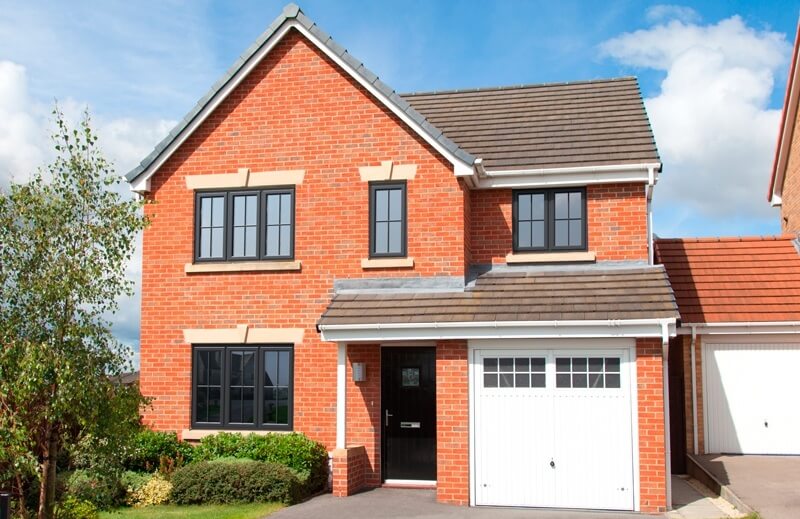 Modern red brick house with black Profile 22 Casement Windows, installed by Great Harwood Windows, offering energy-efficient and secure window solutions.
